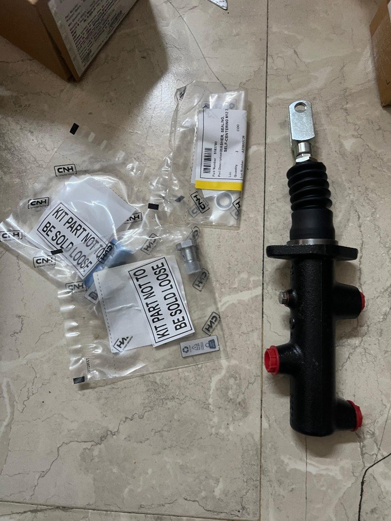 Case 91896671 brake master cylinder kit laid out with CNH Genuine Parts bags pipe union banjo bolt — warehouse photo India export