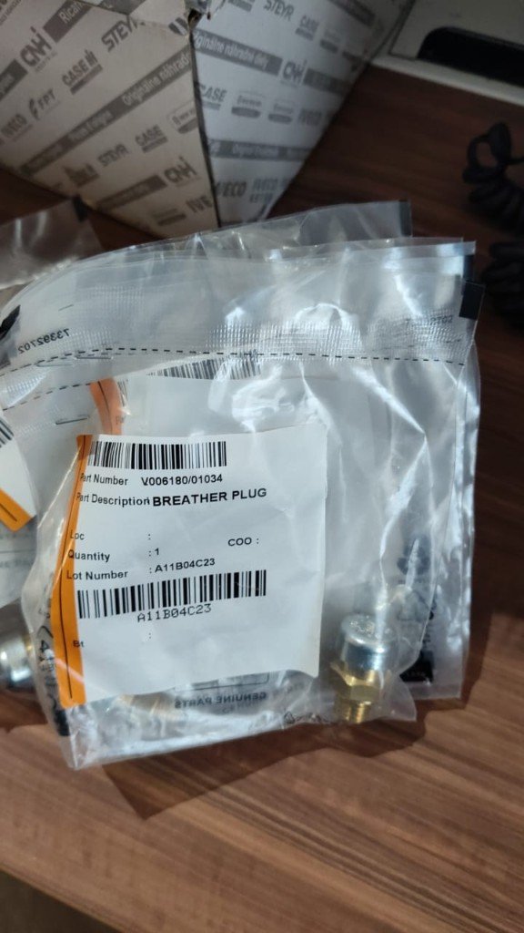 Case CNH V006180/01034 breather plug close label and brass plug visible CNH Industrial Genuine Parts packaging — warehouse photo India export