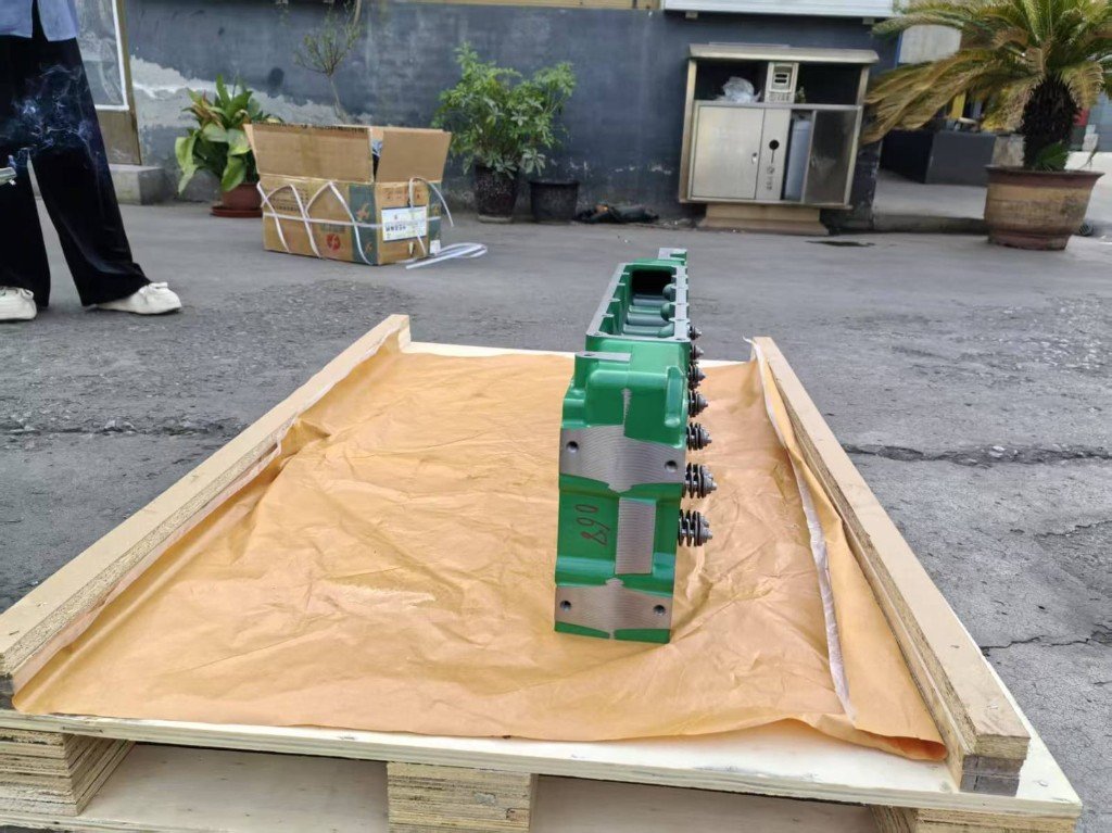 John Deere green cylinder head side view on shipping pallet — warehouse source photo India