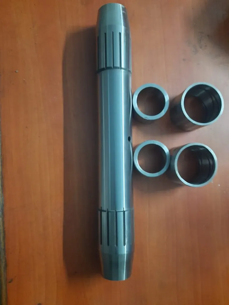 BOMAG road roller centre pin with four steel bushes on a workbench