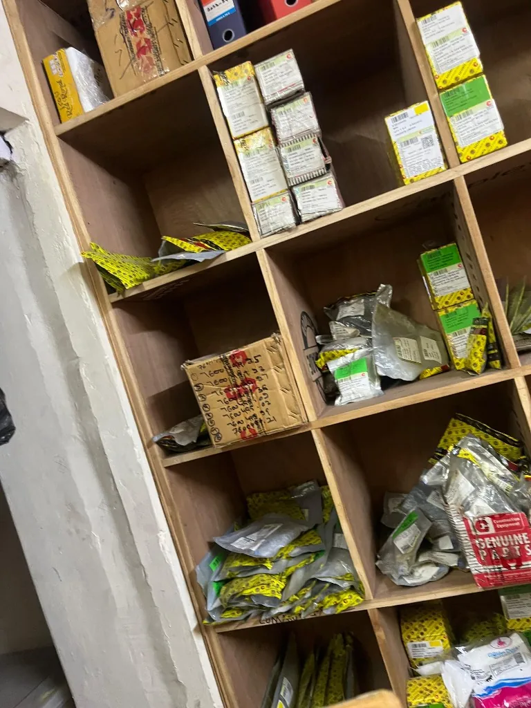 Escorts Kubota Genuine Parts boxes on wooden warehouse shelves — export stock verification photo