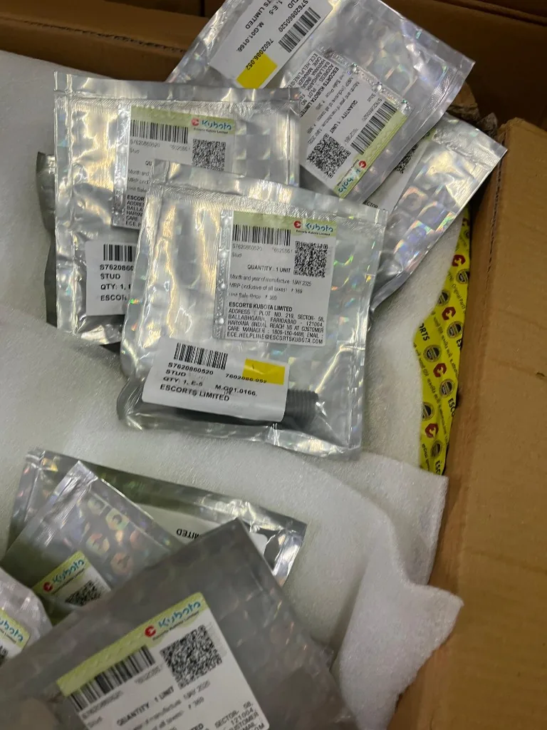 Escorts Kubota yellow Genuine Parts boxes in open export carton — warehouse bulk stock photo