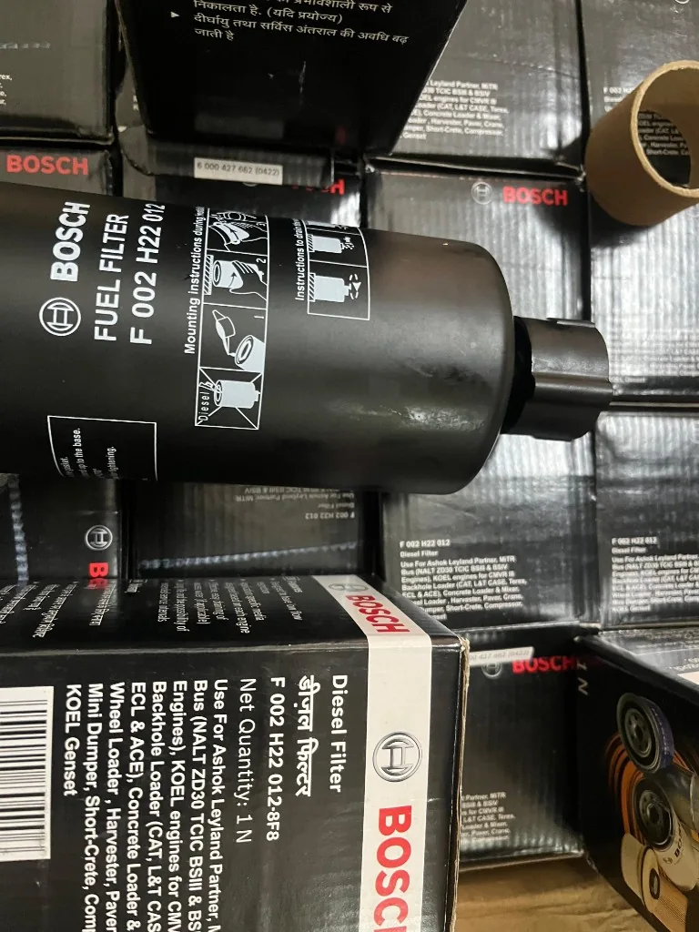 Part No. F002H22012 diesel fuel filter on stacked Bosch boxes — compatibility label visible export photo