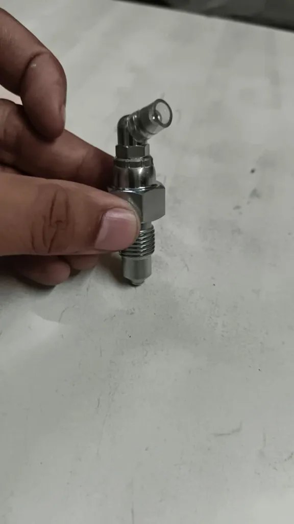 Part No. YD00007823 track tensioner grease nipple assembly angle view undercarriage