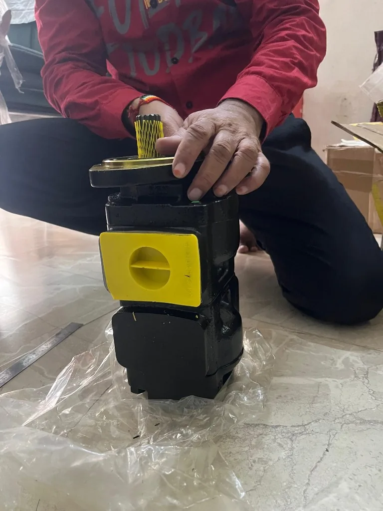 Parker JCB 3DX twin gear hydraulic pump full display kneeling — drive shaft yellow sleeve warehouse photo