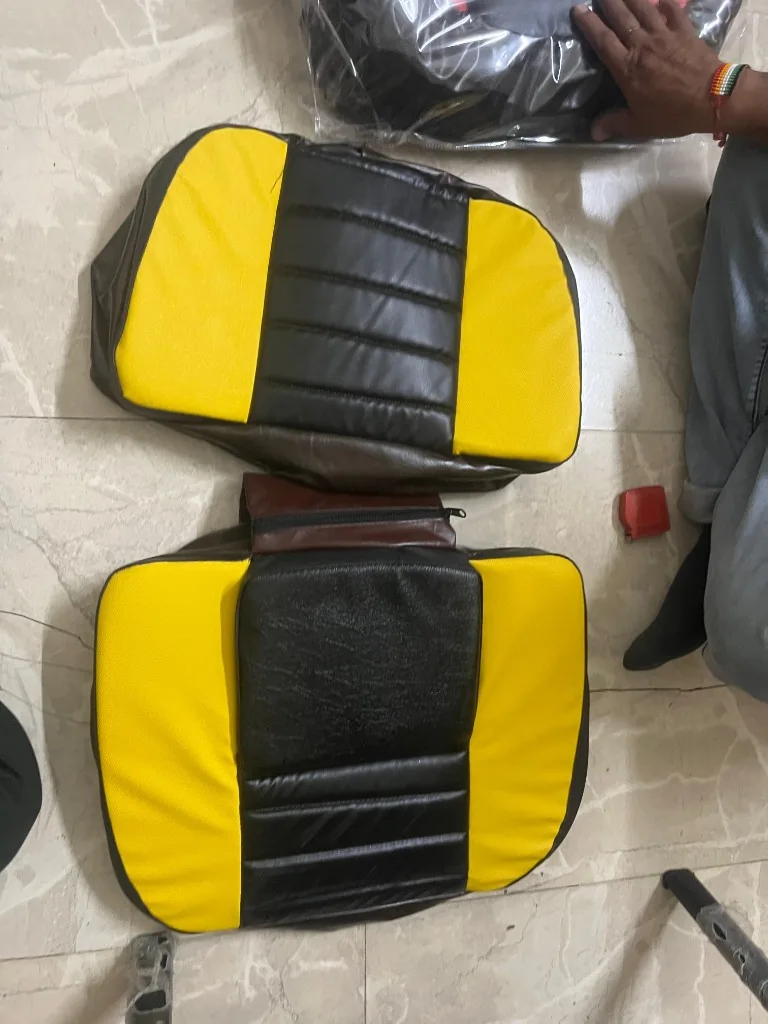 Premium PU tractor seat cover yellow and black two-piece set on warehouse floor — export stock photo India