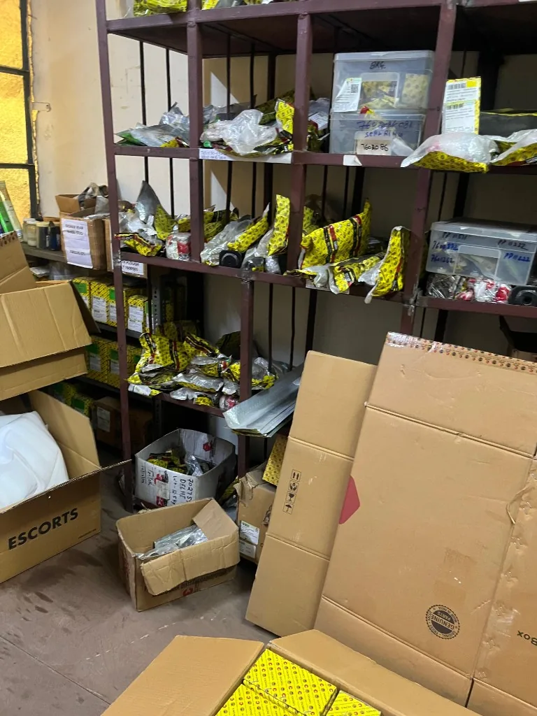 Escorts Kubota warehouse shelves with Genuine Parts seal on yellow packaging — service kit export stock context