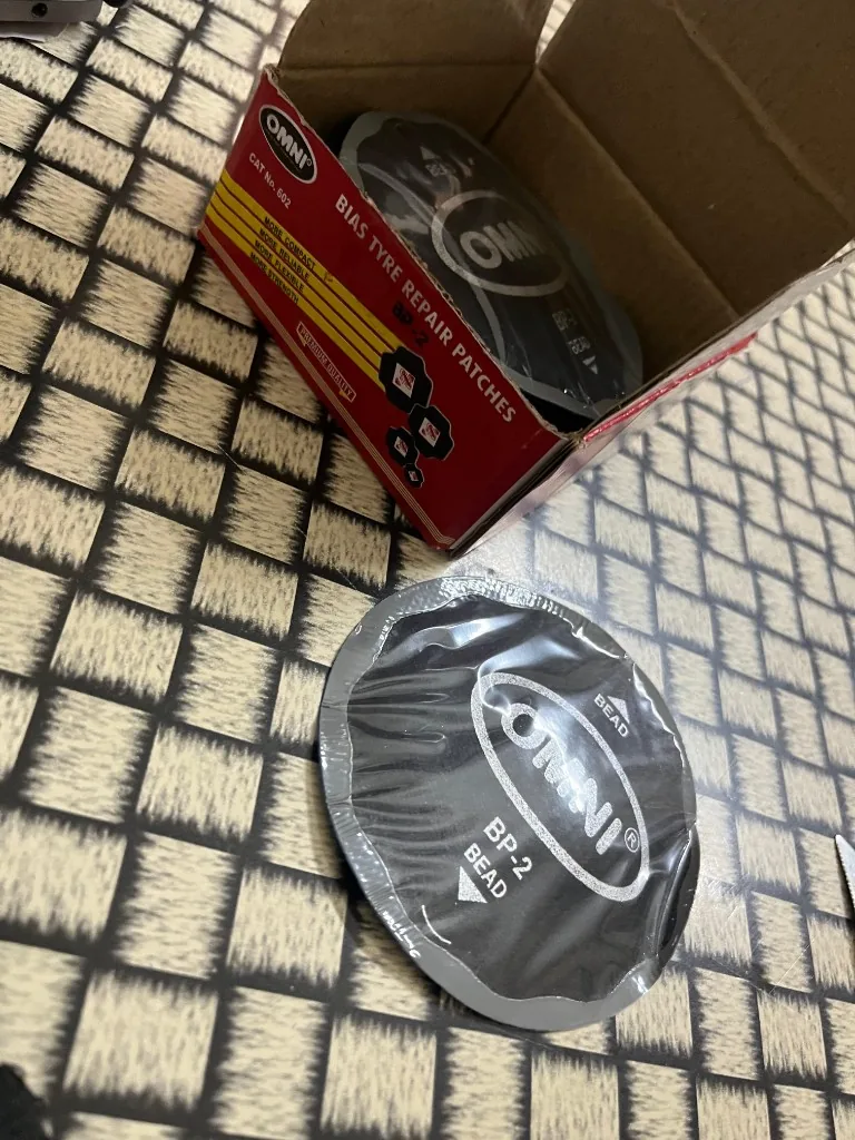 Omni BP-2 bias tyre repair patch close-up — BEAD alignment marking OMNI logo circular patch warehouse photo