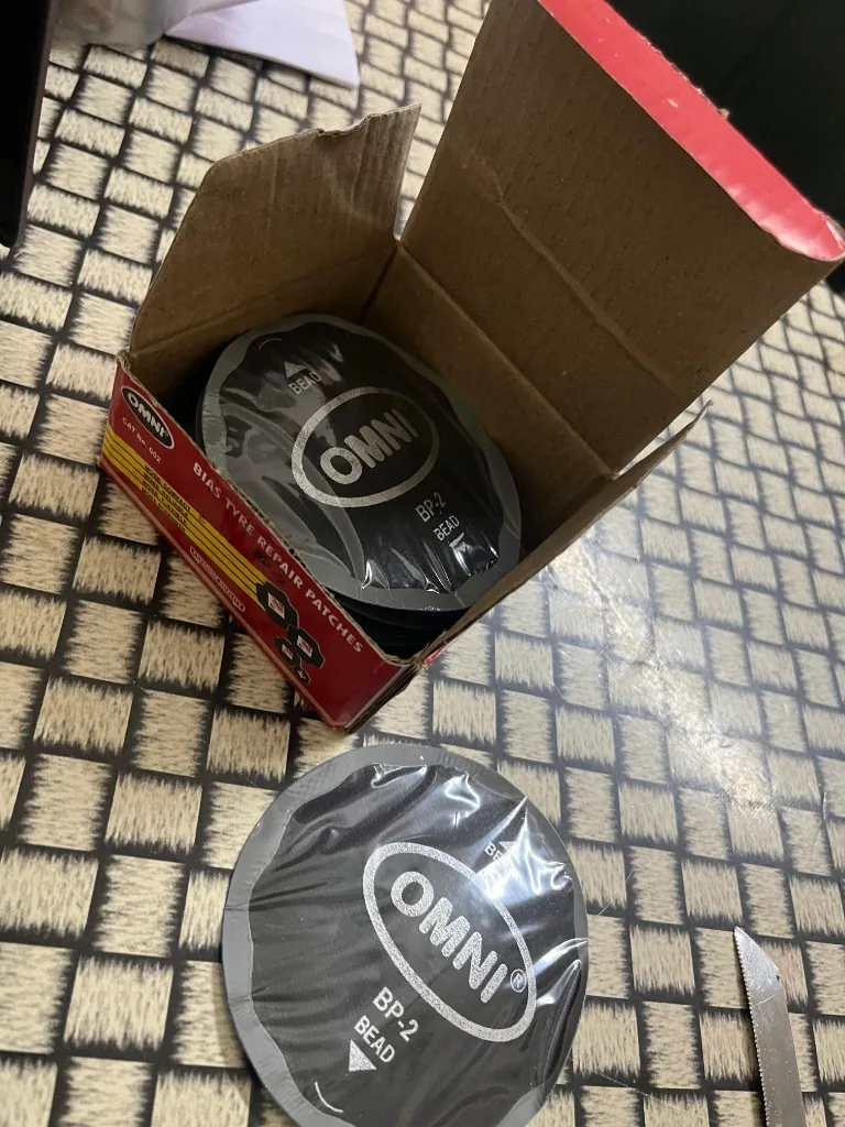 Omni BP-2 CAT 602 open box with stack of bias tyre repair patches — warehouse stock export photo Pioneer Mitra New Delhi